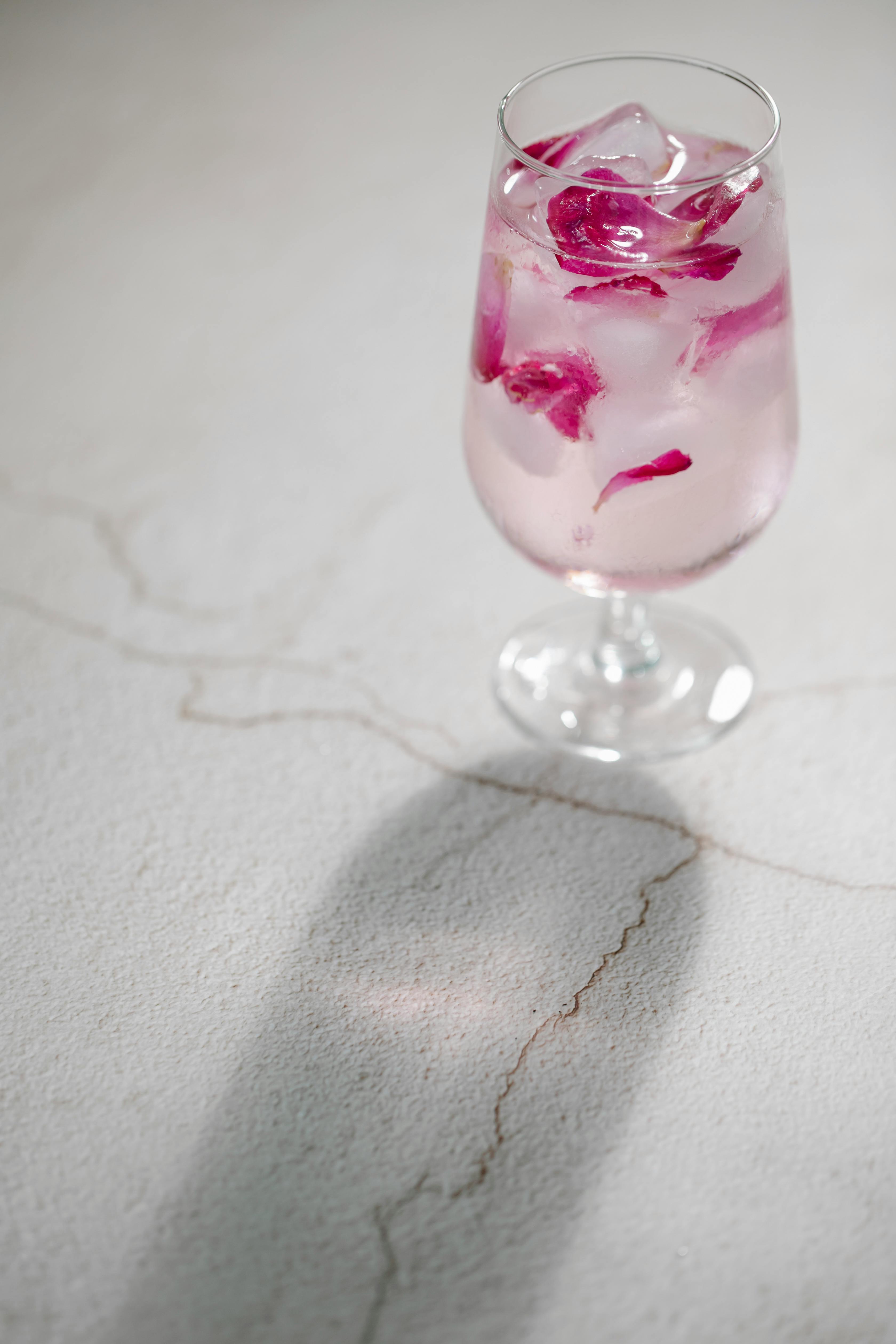 wineglass of iced water with rose petals