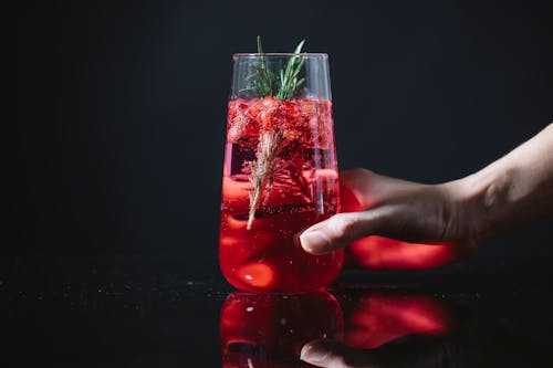 Crop woman with glass of red cocktail