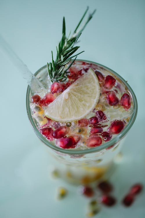 Delicious lemonade with pomegranate seeds and slice of lemon