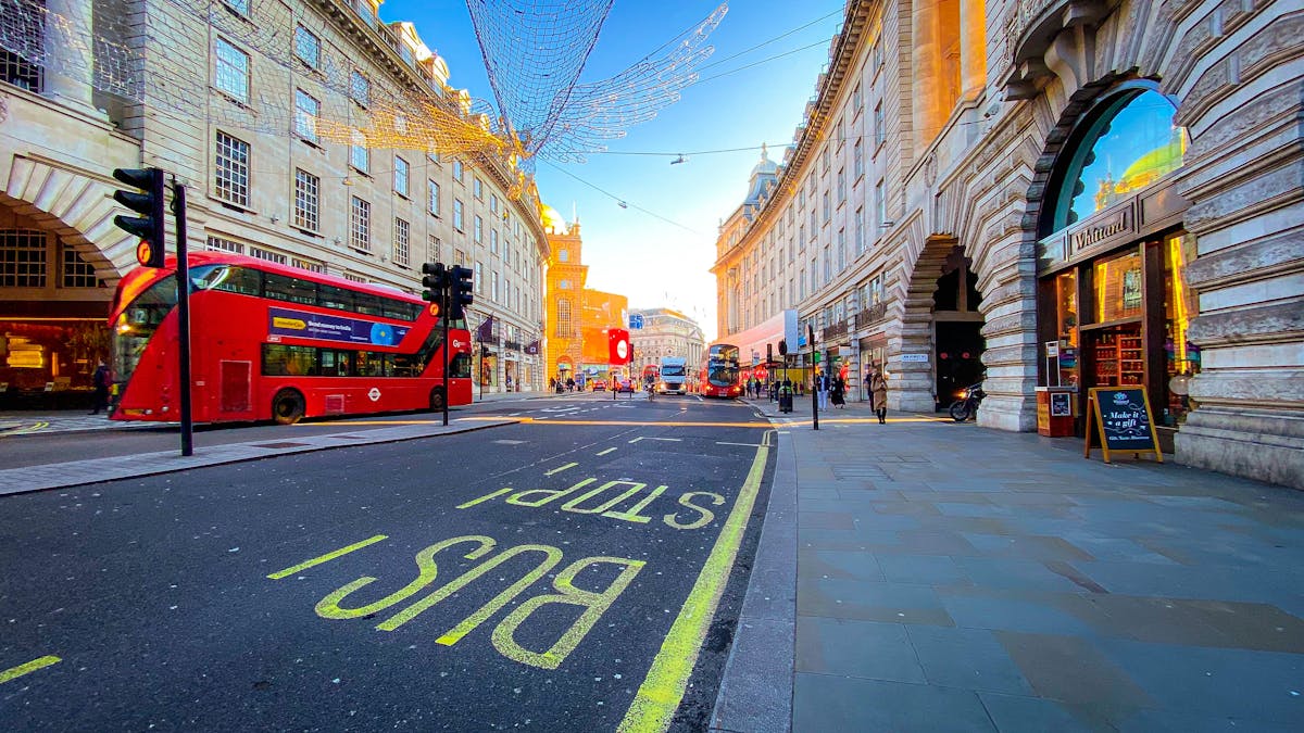 A person holding a journal and pen next to a glass of juice