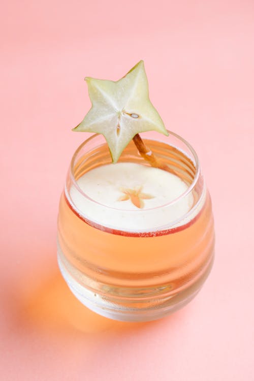Free From above of crystal glass of refreshing drink with slice of apple and decorated with piece of carambola Stock Photo