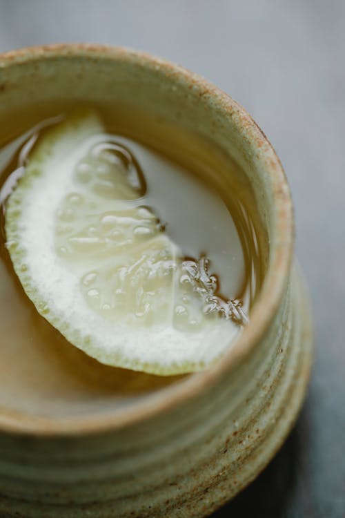 Free From above closeup of fresh aromatic drink with slice of lemon in ceramic cup Stock Photo