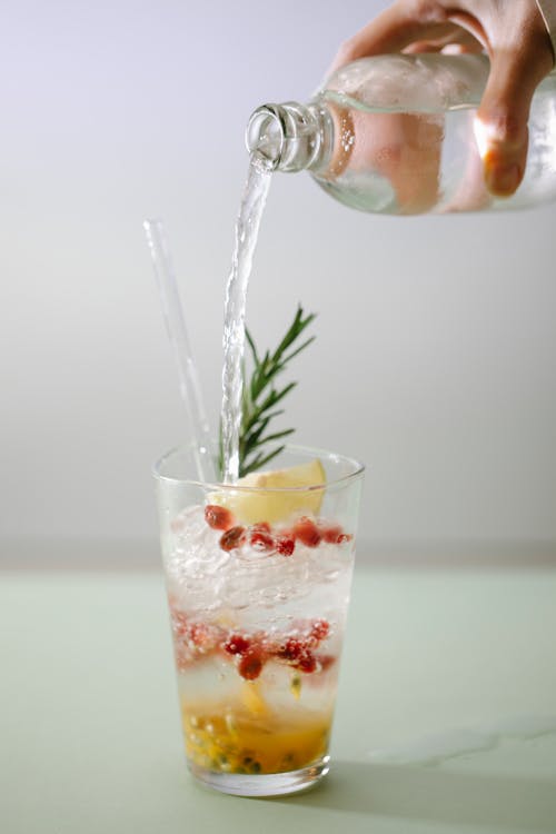 Free Crop person pouring drink into glass with ingredients Stock Photo