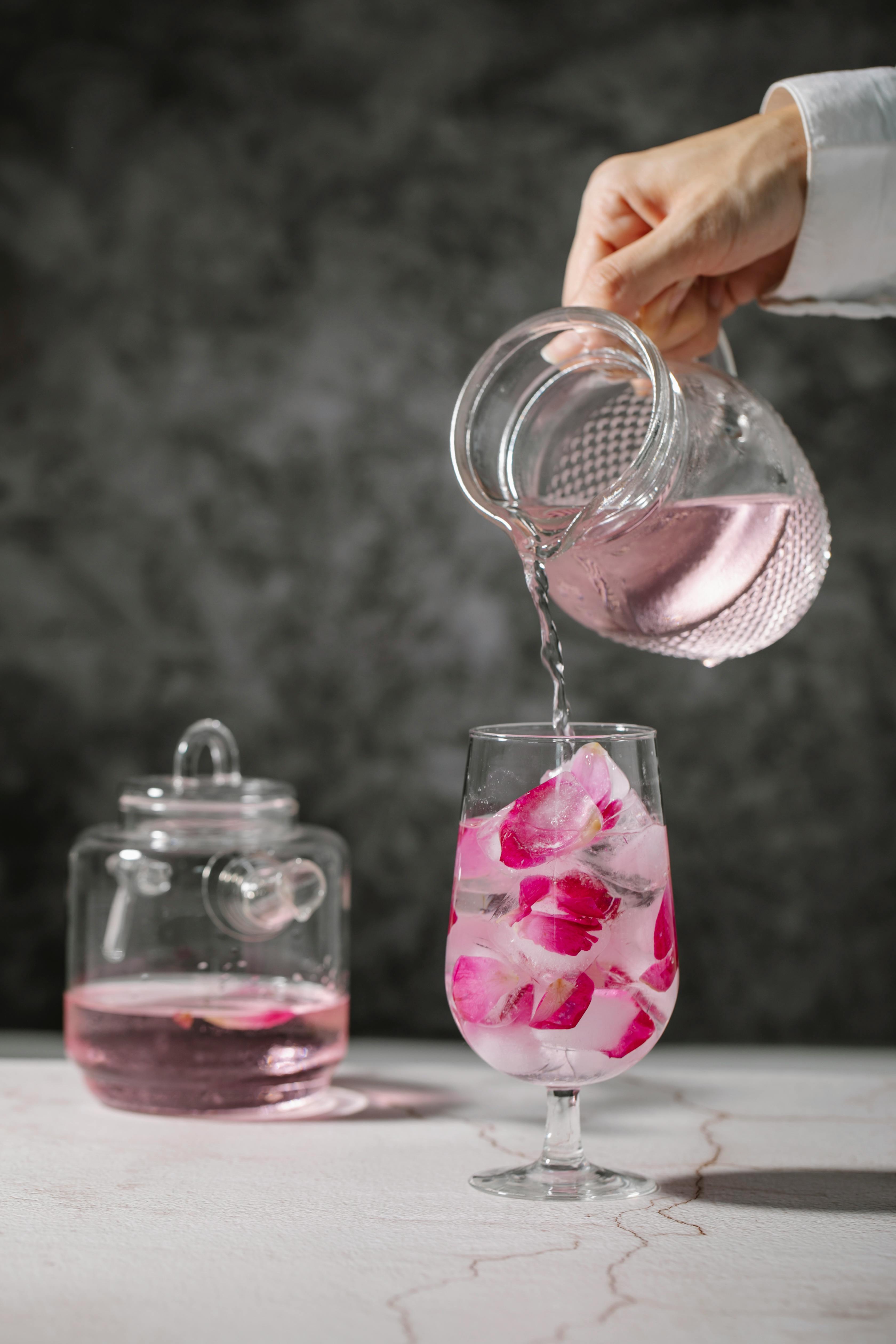 crop person pouring rose water in glass