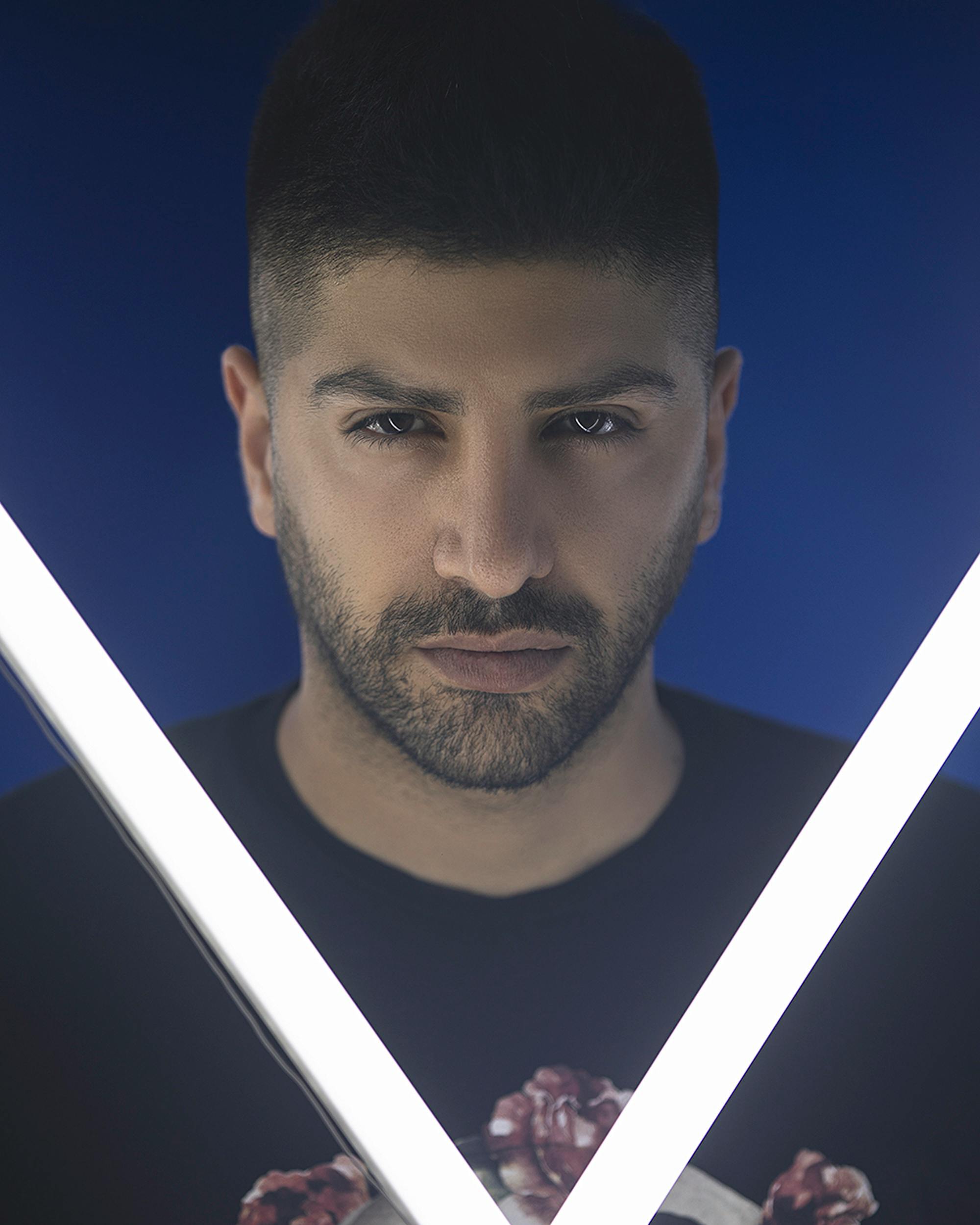Intense studio portrait of a man framed by neon lights, showcasing striking expression.