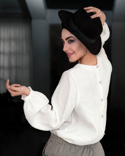 Woman in White Button Up Long Sleeve Shirt Wearing Black Hat
