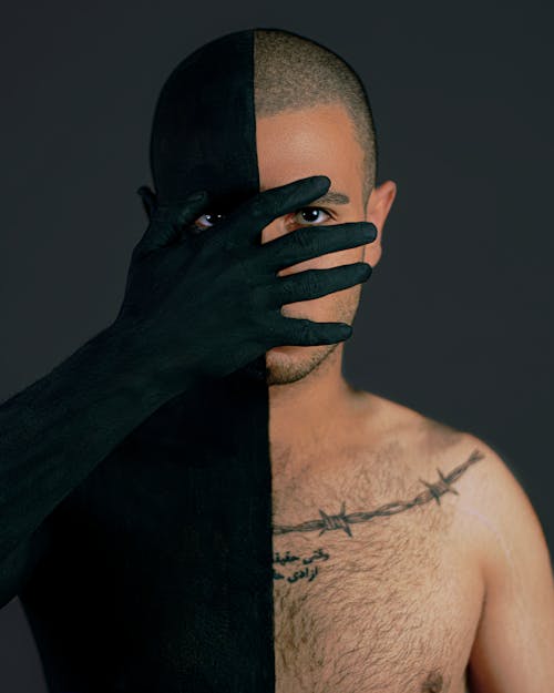 A Shirtless Man Covering His Face with His Hand