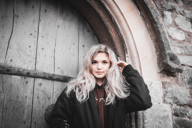 A Beautiful Woman Standing Outside A Wooden Door