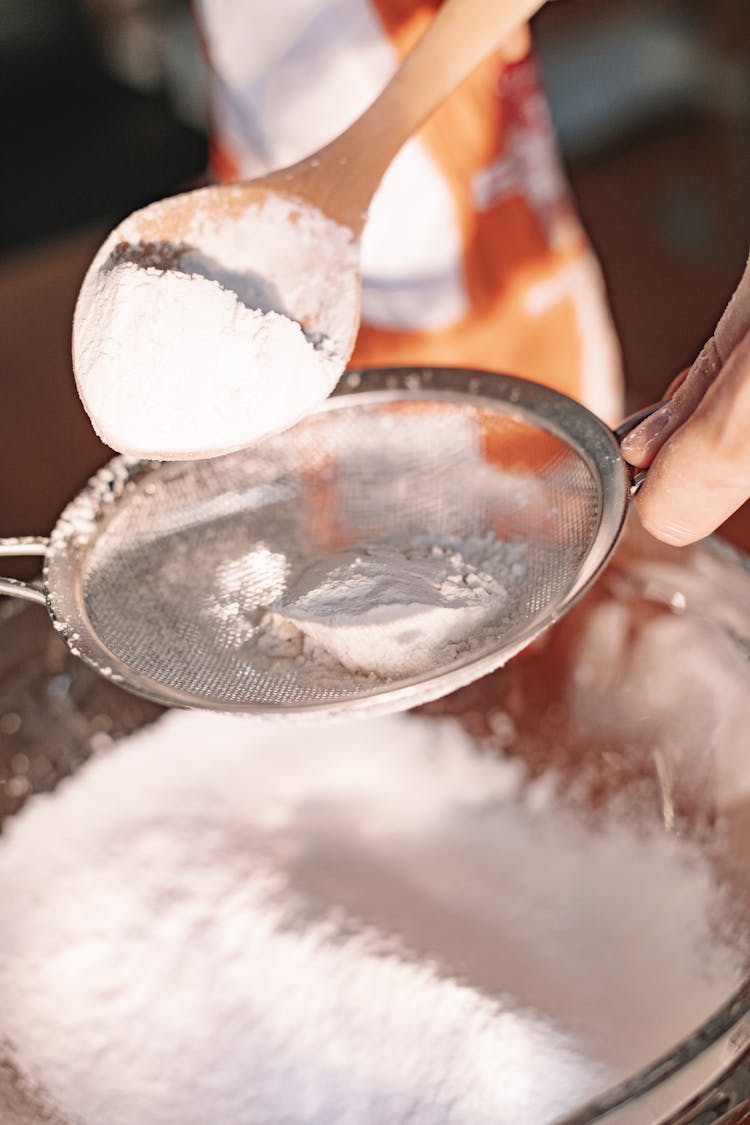 Close-Up Shot Of A Person Sifting Powder