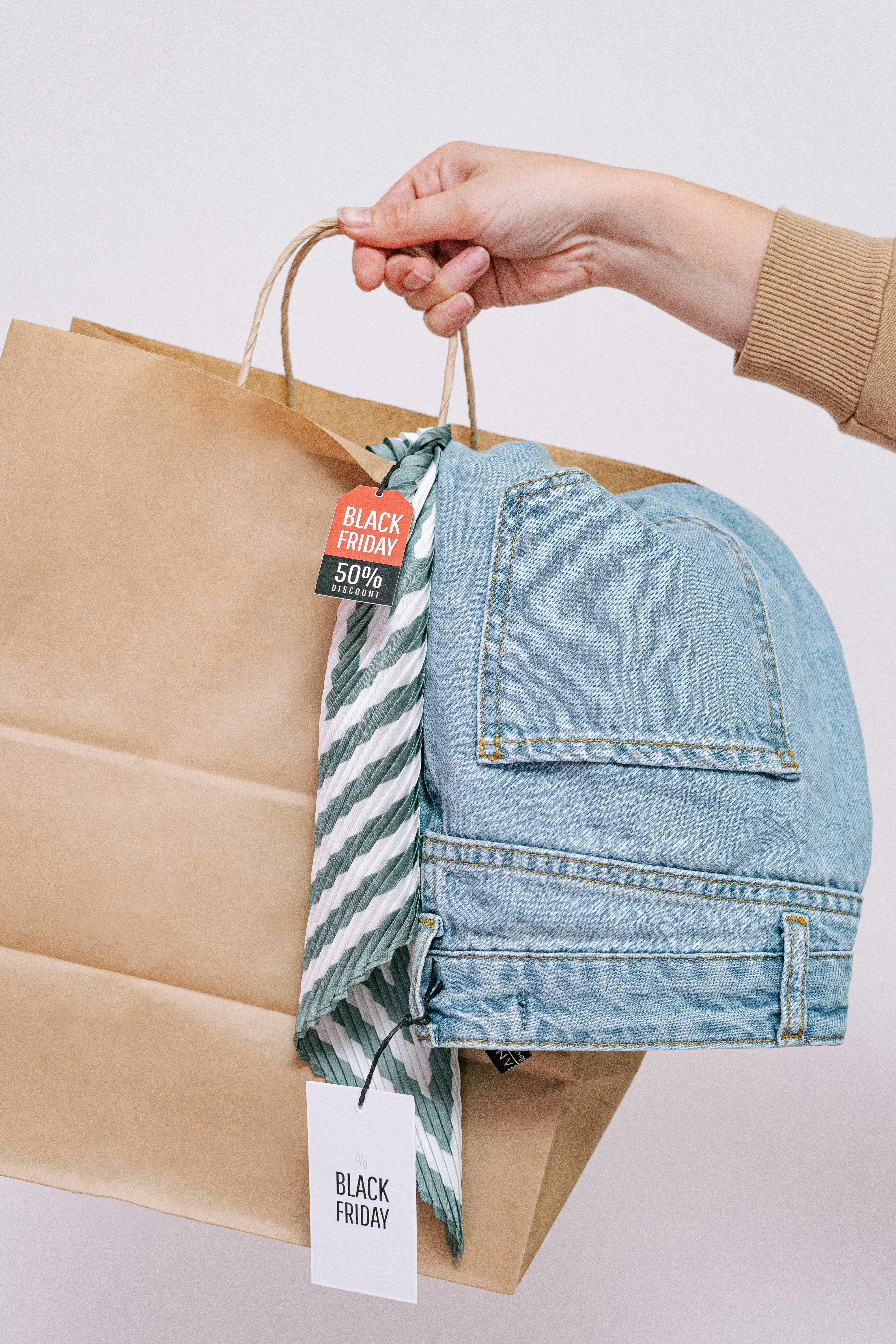 person holding a shopping bag with denim jeans