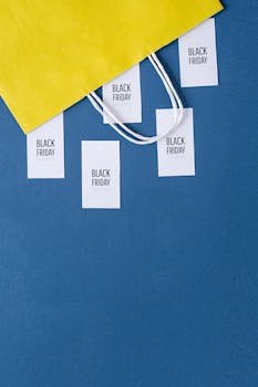 Yellow shopping bag with Black Friday tags on blue background for vibrant sales season imagery.