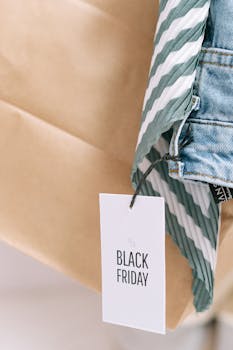 Close-up of Black Friday discount tag tied to denim and striped clothing.