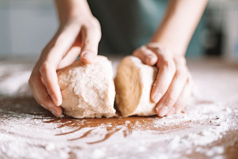 Hands shaping two rounds of dough