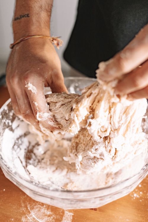 Free Close-up of hands kneading dough in a glass bowl, showing the texture and preparation process. Stock Photo
