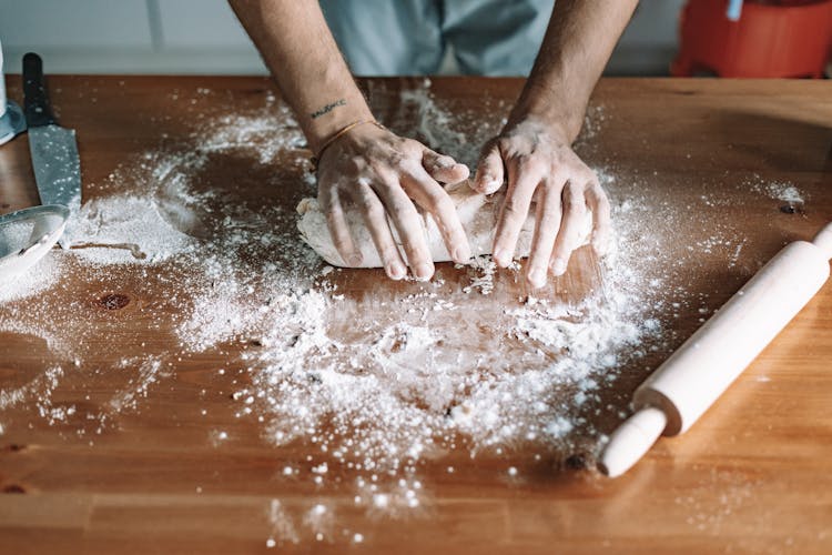 A Person Kneading A Dough