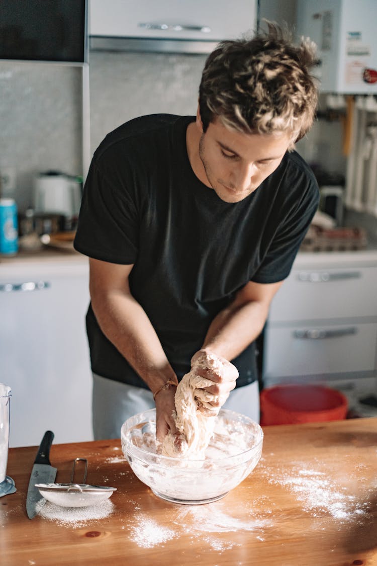 A Man Kneading A Dough