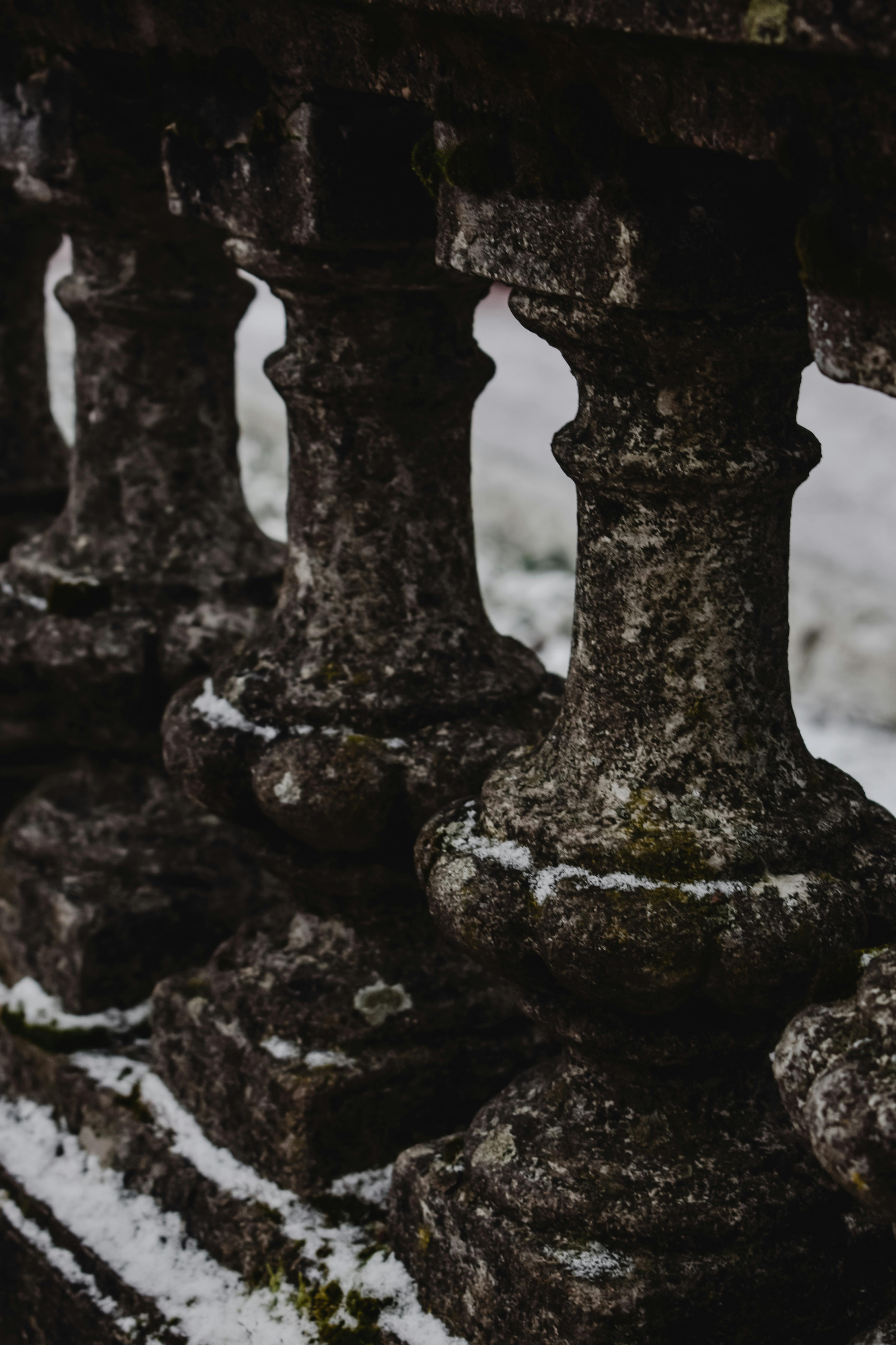 积雪覆盖的老石栏杆的细节特写，捕捉冬日的纹理