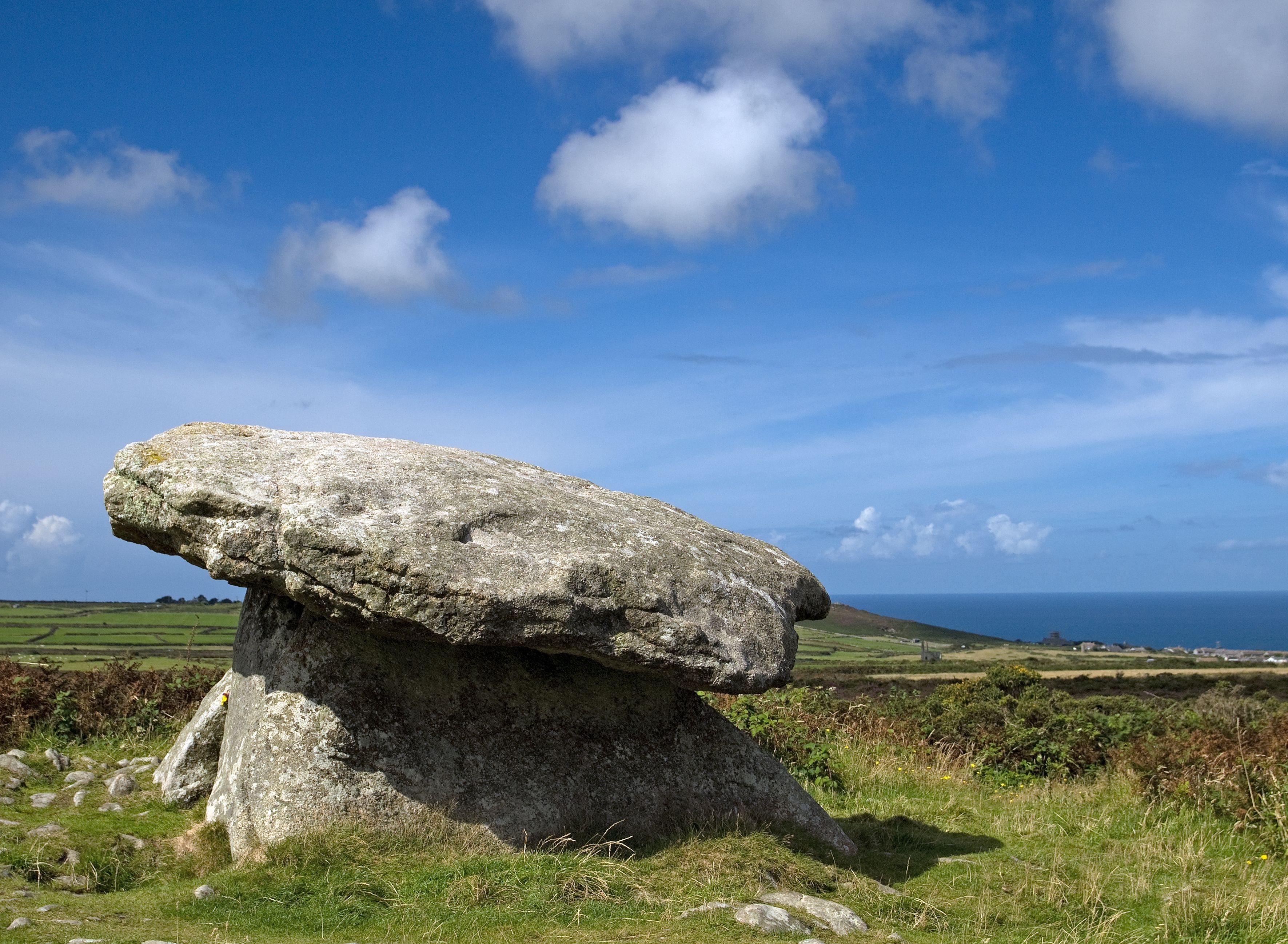 Explore the mystical landscape of an ancient Neolithic dolmen under a clear summer sky in England.
