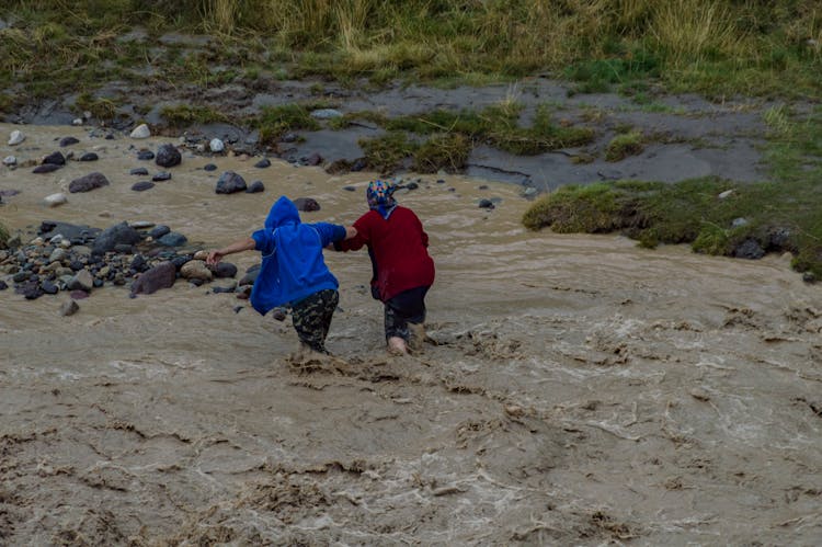 People Crossing River In Flood