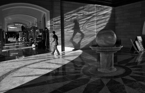 Free Grayscale Photo of a Man Walking in the Hallway Stock Photo