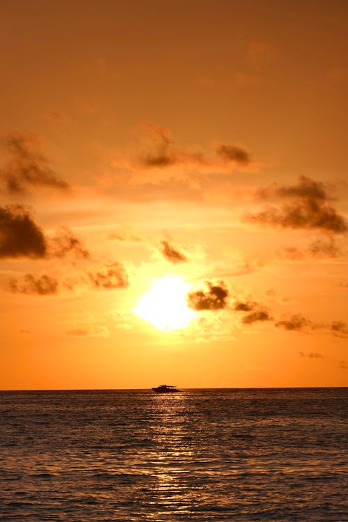 Silhouette of a Boat on the Sea during Sunset