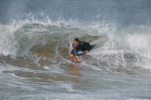 Man in Black Wetsuit Surfing 