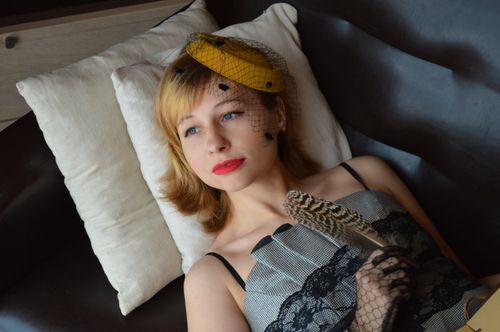 Free From above of young pondering female author with red lips in old fashioned clothes with feather looking away on sofa Stock Photo