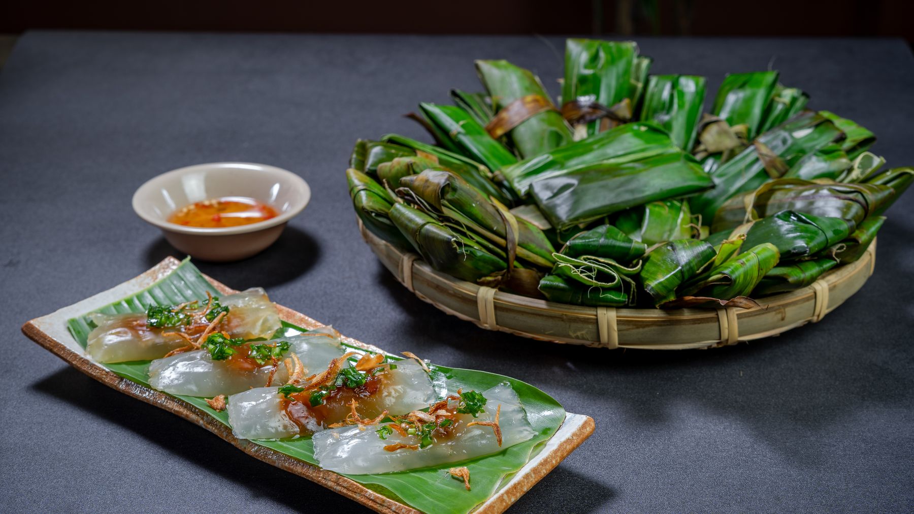 Deliziosi banh bot loc vietnamiti serviti su foglie di banano con una saporita salsa di accompagnamento.