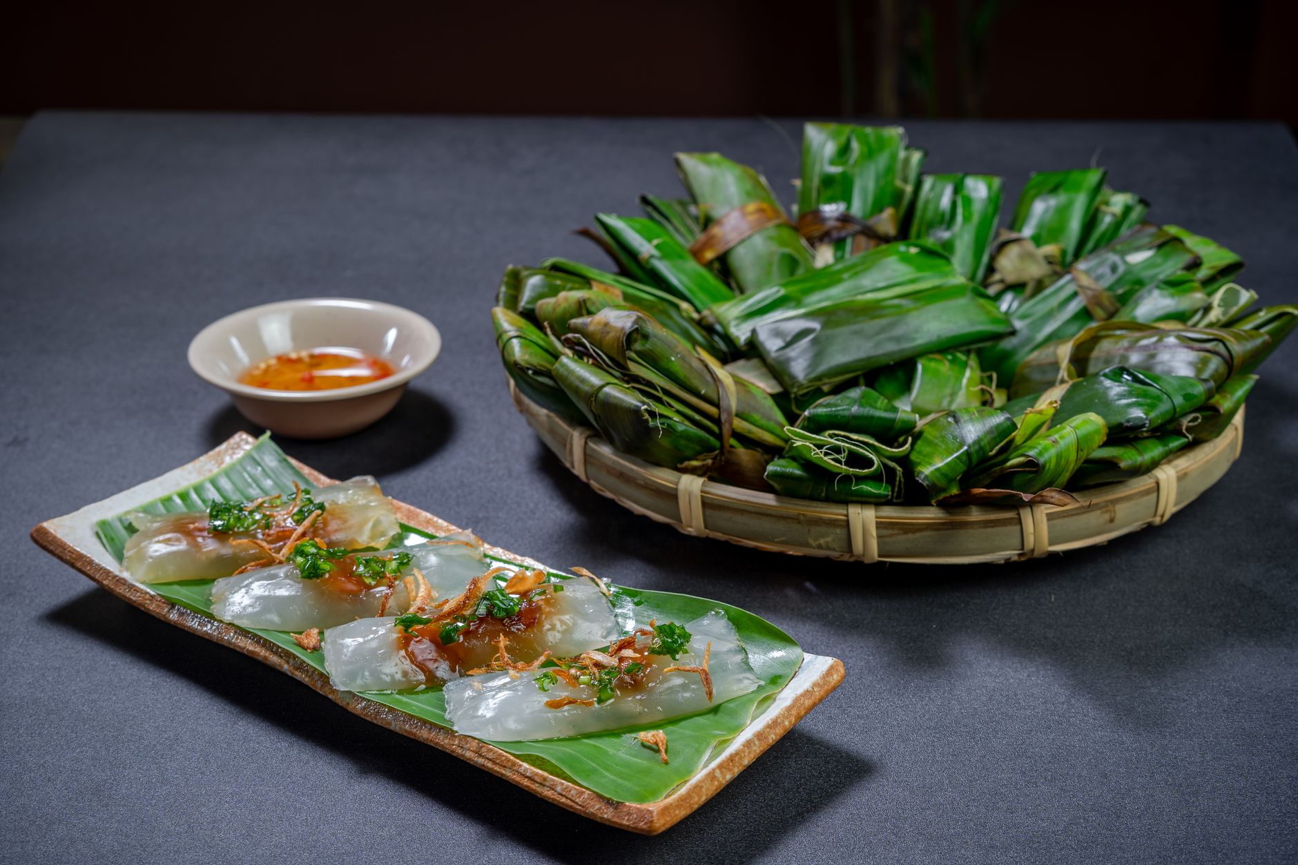 Delicious Vietnamese banh bot loc served on banana leaves with a flavorful dipping sauce.