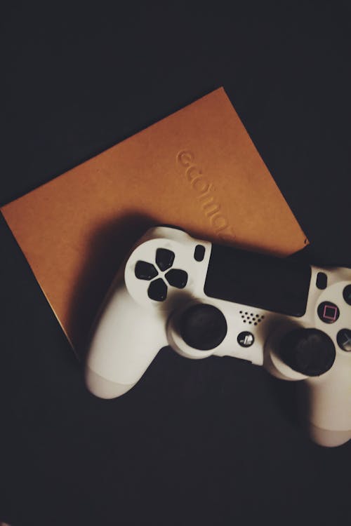 White Dualshock 4 on Brown Book