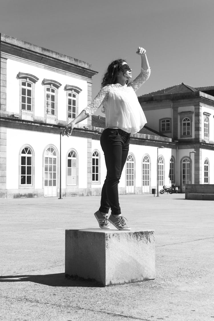 Woman In A Dance Pose On A Square In City 