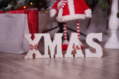 Free Close-up of wooden 'XMAS' decoration with festive Santa figure and gifts in a cozy setting. Stock Photo