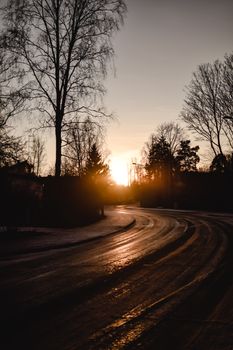 芬兰赫尔辛基冰冷的道路上，宁静的冬季日落洒下温暖的色调