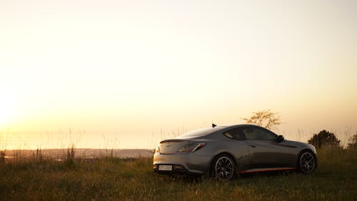 Gray Car Parked on Green Grass Field during Sunset