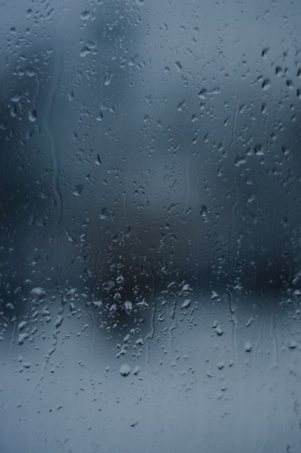 Close-up of raindrops on a window in Estonia, capturing a moody, rainy day feel.