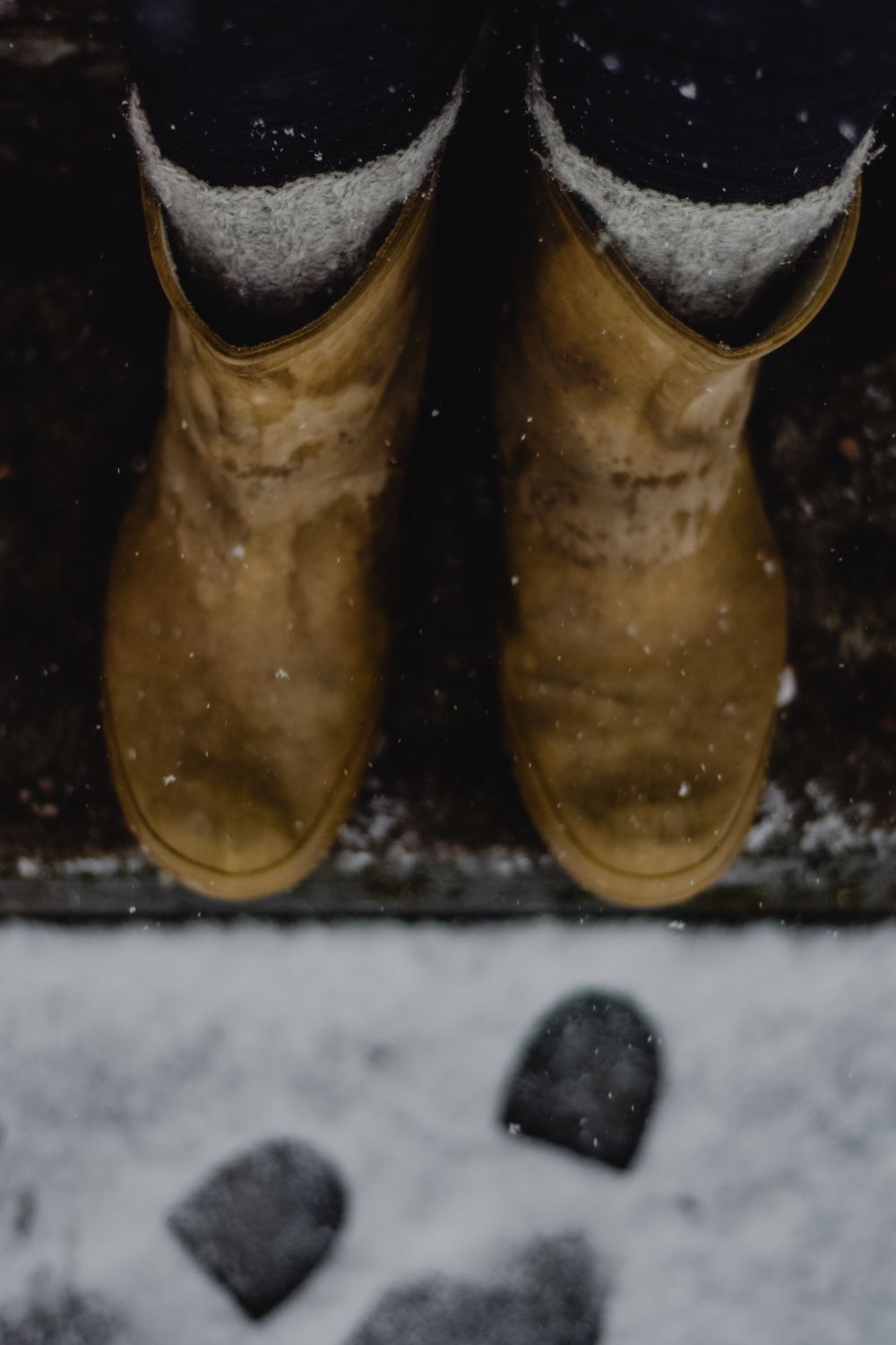 Wool socks inside suede winter boots on a snowy doorstep