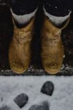 Wool socks inside suede winter boots on a snowy doorstep