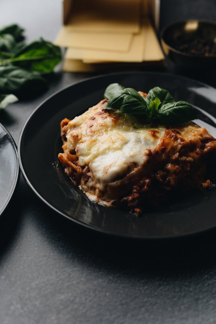 Cheesy Lasagna On A Black Plate