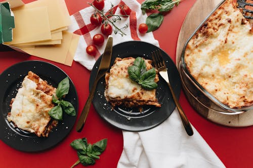 Free Two Servings Of Lasagna On Black Plates Stock Photo
