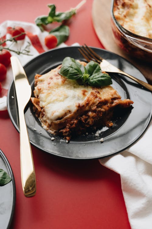 Free Baked Lasagna on a Black Plate Stock Photo