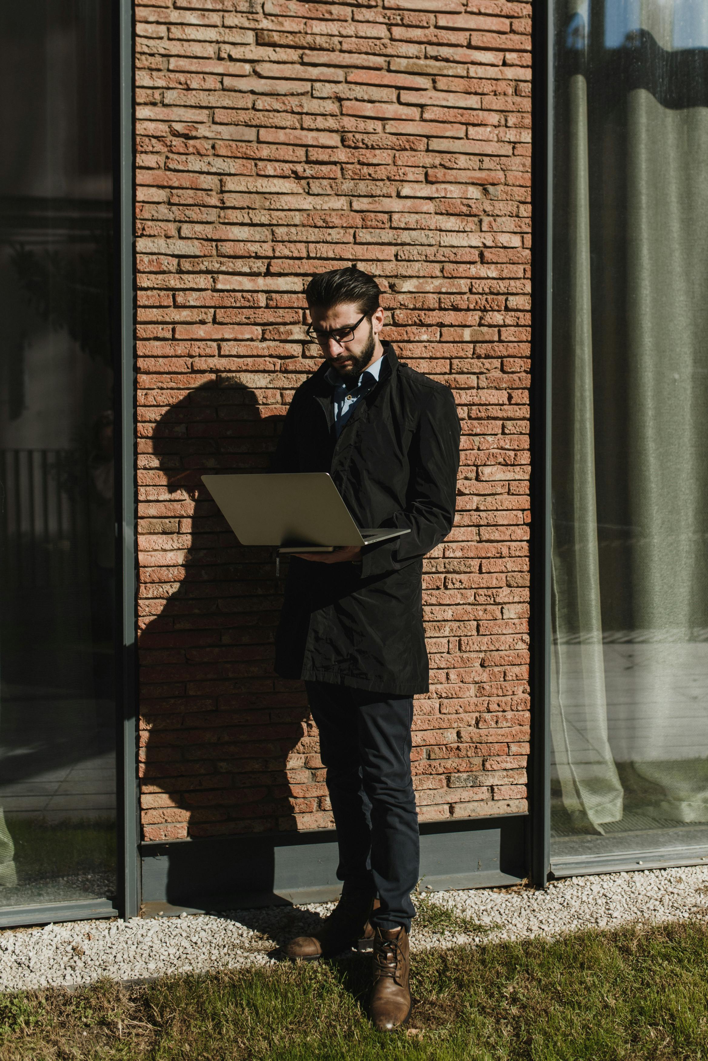 man standing using a laptop