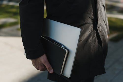 Free 銀のラップトップコンピューターを保持している黒いボタンアップシャツの人 Stock Photo