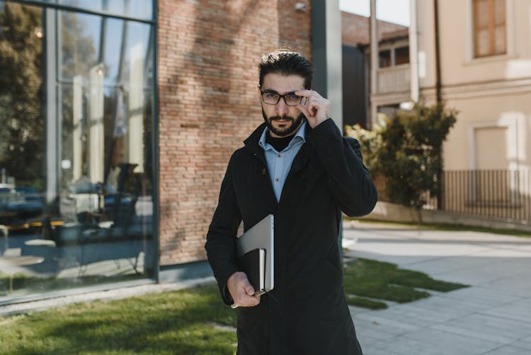 Photo Of A Handsome Man Touching His Eyeglasses While Looking At The Camera