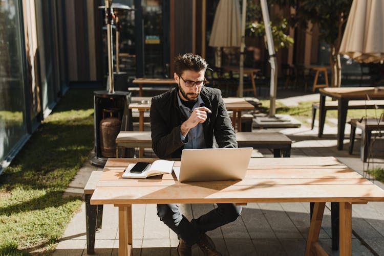 Man In Black Jacket Sitting At The Al Fresco