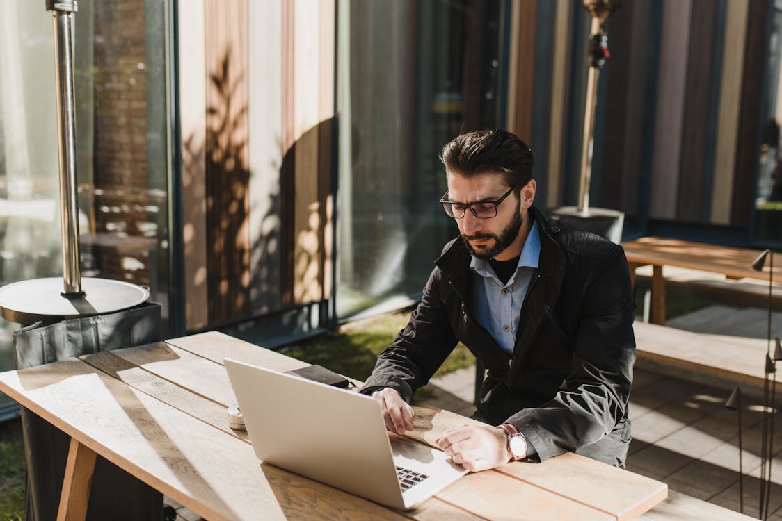 Man at the Table Using Laptop