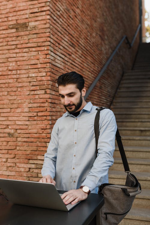 A Man Working on His Laptop Near the Stairs