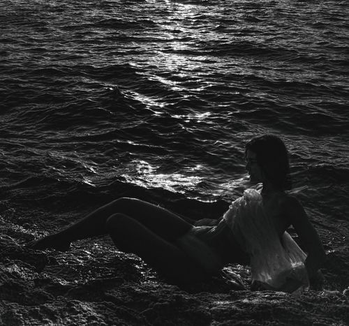 Free Silhouette of a woman by the ocean in monochrome, showcasing natural beauty. Stock Photo