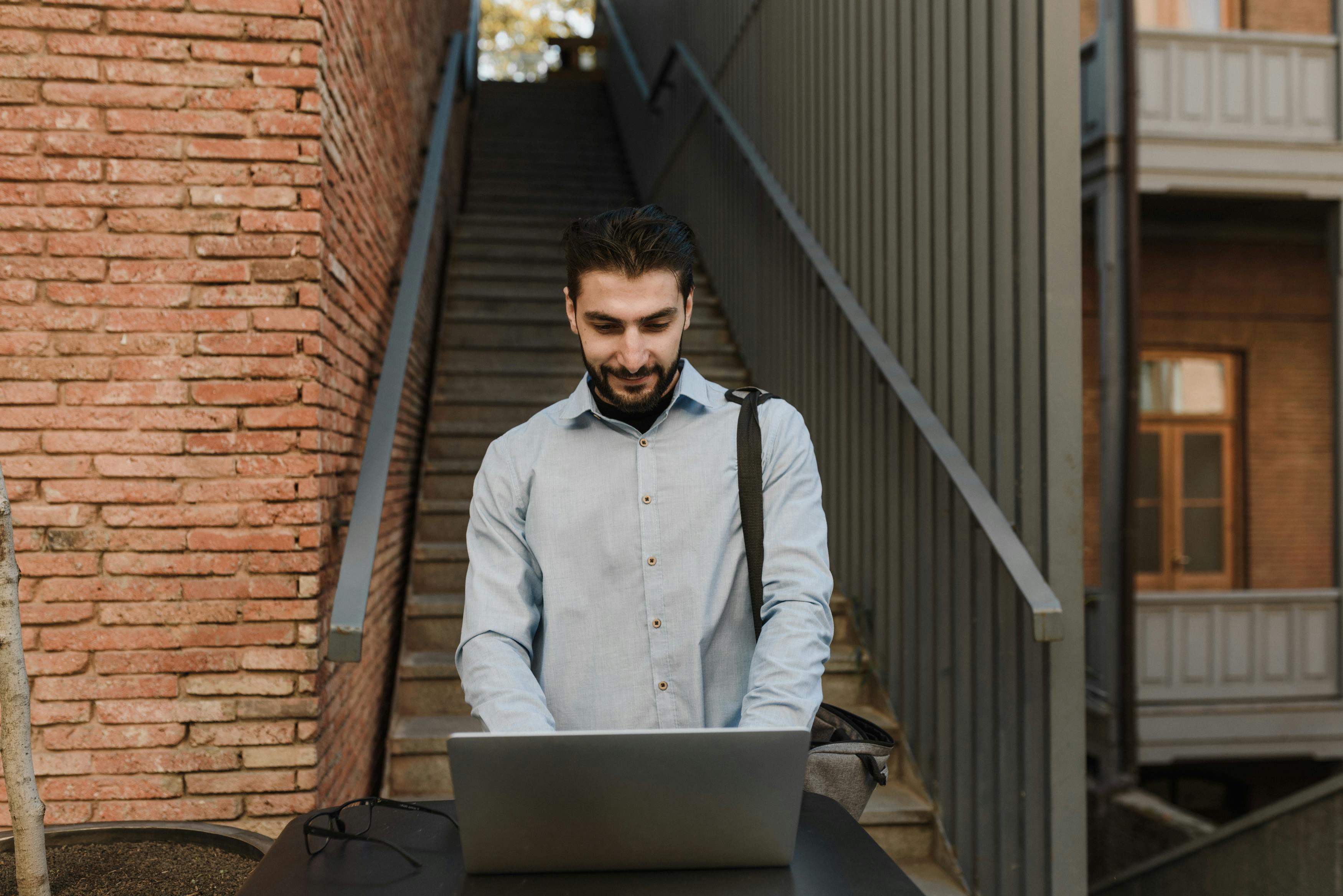 a man working on his laptop while standing