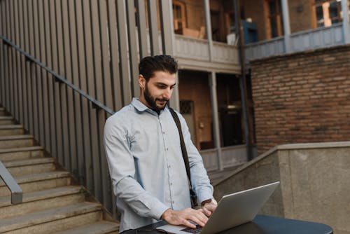 A Handsome Man Using a Laptop while Standing