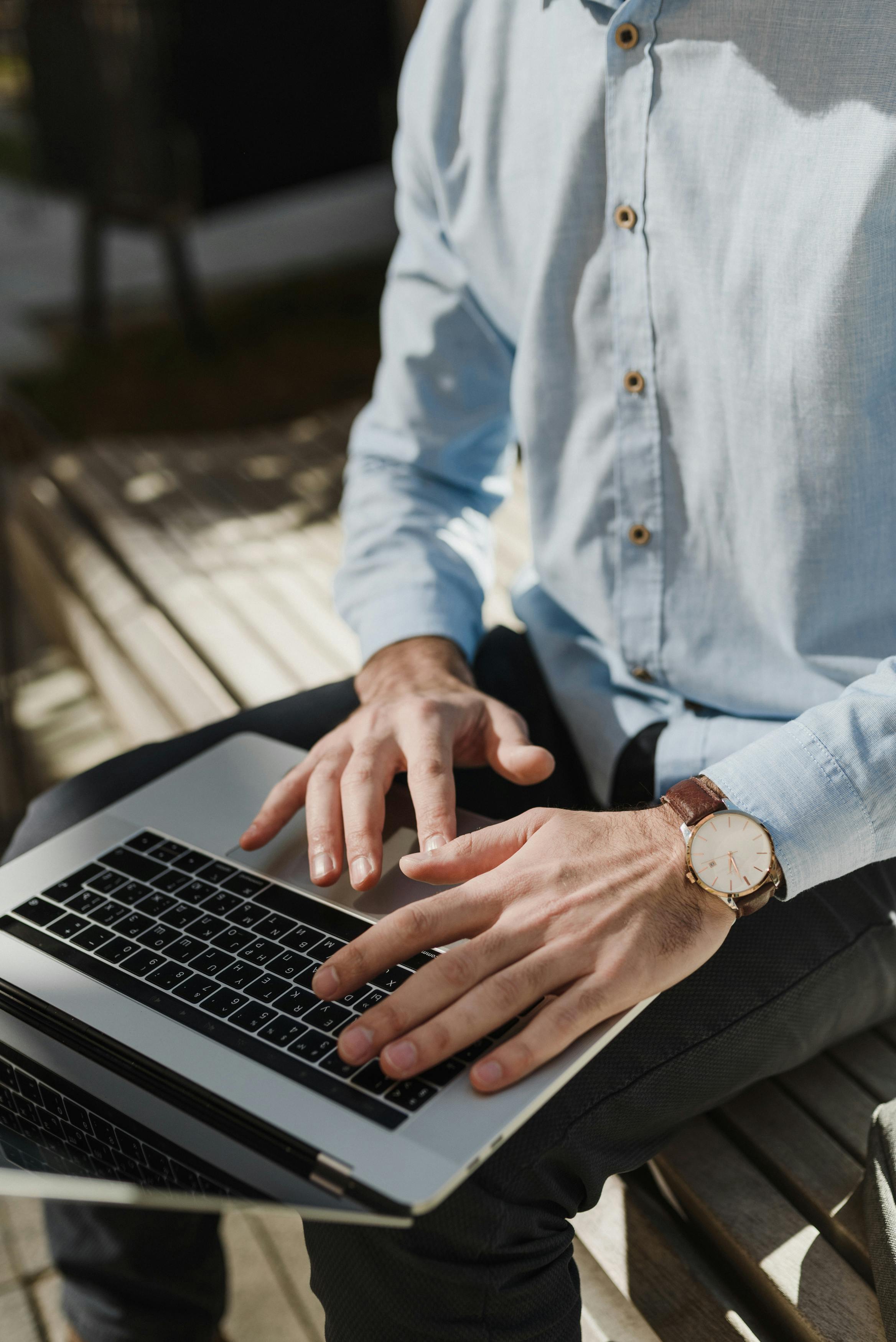 crop photo of man using macbook pro